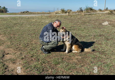 Kumanovo, Macédoine - 22 septembre 2016 : Man with dog in mountain meadow Banque D'Images