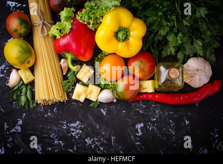 Concept de cuisine italienne. Les pâtes, tomate, huile d'olive, le poivre, le persil et le fromage. Focus sélectif. Vue d'en haut Banque D'Images