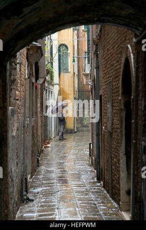 Homme debout sur la rue mouillée pendant la pluie, Venise, Vénétie, Italie Banque D'Images