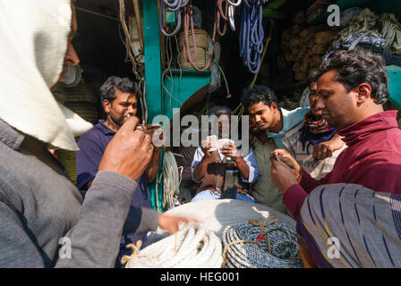 Khulna : vieille ville ; les hommes au jeu de carte en face de shop pour les cordes, division de Khulna, Bangladesh Banque D'Images