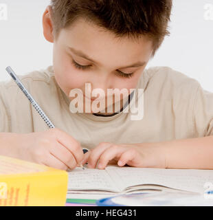 Écolier, garçon de sept ans faire ses devoirs Banque D'Images