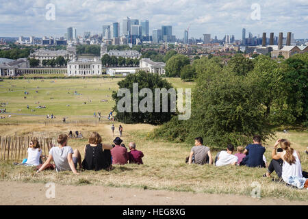 Les gens à admirer la vue de la Maison de la Reine et de Canary Wharf à partir du haut de la colline de Greenwich Park, Londres, Angleterre Banque D'Images