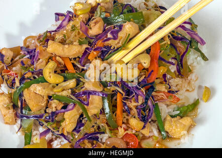 Close up studio shot de légumes poulet chop suey servi sur riz au jasmin et baguettes Banque D'Images