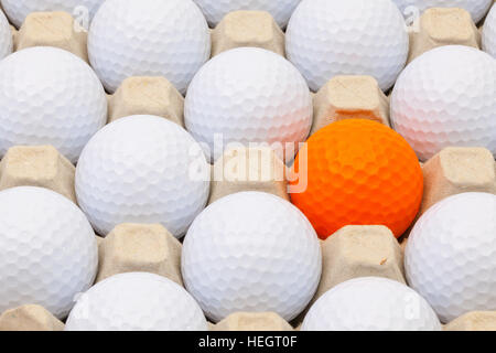 Balles de golf blanc et orange dans la boîte pour les oeufs Banque D'Images