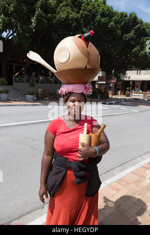 Femme sud-africaine locale transportant des marchandises du vendeur sur sa tête, Wilderness, Afrique du Sud Banque D'Images