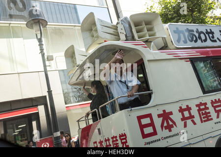 Les membres du Parti communiste japonais faisant campagne à partir de l'arrière d'un autobus à Shibuya, Tokyo, Japon. Banque D'Images