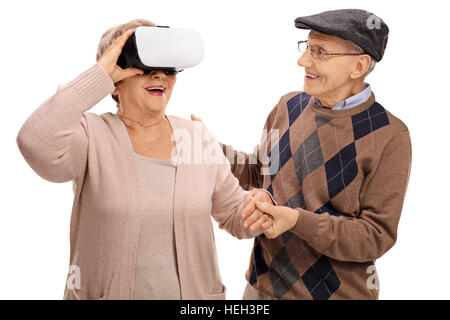Femme mature à l'aide d'un casque VR avec un homme mûr tenant sa main isolé sur fond blanc Banque D'Images
