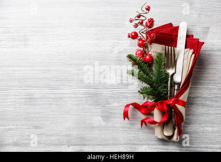 Ensemble de couteau et fourchette de table avec serviette, de branches de sapin de noël, fruits rouges et ruban sur fond de bois gris copy space Banque D'Images