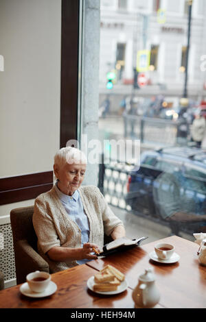 Auteur principal de ses notes de lecture tout en ayant brunch de cafe Banque D'Images