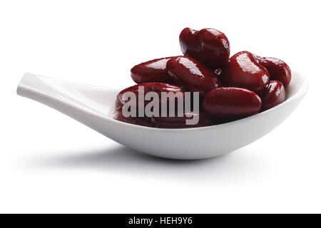 Cuillère blanc céramique avec des haricots en conserve (graines de Phaselous vulgaris) dans la sauce. Chemins de détourage, séparés de l'ombre Banque D'Images