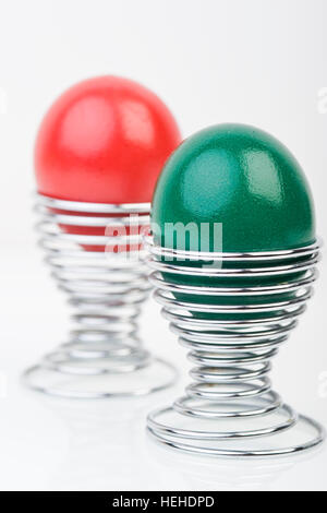 Le rouge et le vert oeufs de Pâques en eggcups Banque D'Images