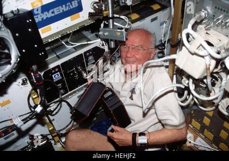 La mission STS-95 de la NASA, l'astronaute John Glenn se déplace Séparation Organique Avancée cartouches à la module Spacehab de la navette spatiale Discovery le 17 novembre 1998 dans l'orbite de la Terre. Banque D'Images