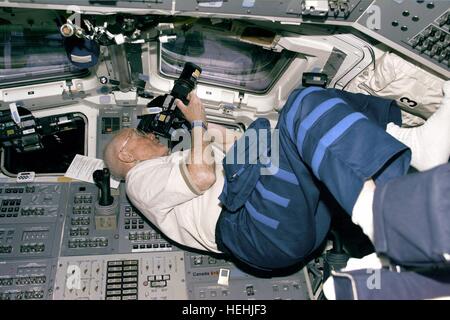 La mission STS-95 de la NASA, l'astronaute John Glenn prend des photos par la fenêtre de la navette spatiale Discovery après envol le 30 octobre 1998 dans l'orbite de la Terre. Banque D'Images