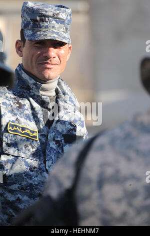 Un policier national iraquien de 8e Brigade (Falcon Brigade), 2ème Division, la police nationale irakienne, accueille des soldats américains de F Compagnie, 2e Bataillon du 505th Parachute Infantry Regiment, 3e Brigade Combat Team, 82e Division aéroportée, au poste de sécurité commune, Beladiyat Muhallah Beladiyat 732 dans l'est de Bagdad,,, l'Iraq, le 5 janvier 2009. La formation à la sécurité commune Humvee Gare 143846 Beladiyat Banque D'Images