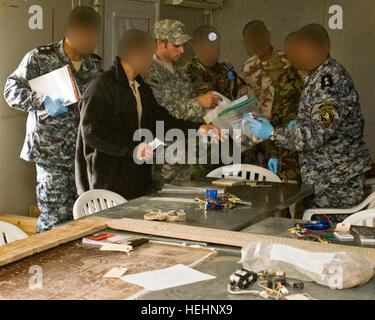 Des soldats irakiens et des agents de police travaillent ensemble pour trouver des indices dans un environnement de formation au camp de Dhi Qar, la 10e armée iraquienne, 11 janvier. Avec l'IP et IA complètement dans le plomb, l'équipe de combat de la 4e Brigade, 1e Division de cavalerie, a offert un cours de formation des formateurs à la base de clés dans le sud de l'Iraq. Nom de visages et cassettes ont été brouillées pour protéger l'identité de ces personnels, en raison de la nature délicate de leur travail. L'équipe de renseignement militaire enseigne l'armée irakienne, la police irakienne des tactiques d'enquête 151489 Banque D'Images