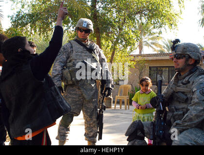 Le s.. Adrian Gonzalez (à droite), un natif de San Antonio, qui sert avec le 2e Stryker Brigade Combat Team, 25e Division d'infanterie, Multi-National Division-Baghdad, et le sergent. Kris Molinar, un Rosemead, Californie, indigène, aussi avec la 2ème SBCT, 25 Inf. Div., parler avec les jeunes enfants irakiens 16 janvier à Sheik Nadeem Tammimi's house en Taji, au nord de Bagdad. Les soldats étaient dans la zone avec le général Jeffery Hammond, un Hattiesburg, au Mississippi, des autochtones, général commandant de la DN-B et la 4ème Inf. Div., et le colonel Todd McCaffrey, commandant du 2e SBCT, 25 Inf. Div., qui s'étaient réunis avec le cheik. Je Banque D'Images