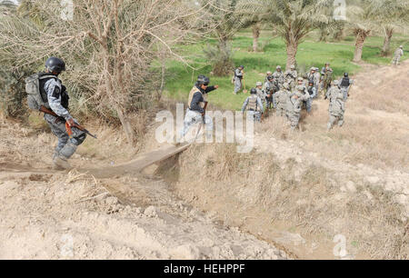 Des agents de la police nationale affectés à la 8e Brigade, 2e NP NP, division de parachutistes et affecté à la Compagnie A, 2e Bataillon du 505th Parachute Infantry Regiment, 3e Brigade Combat Team, 82e Division aéroportée, Multi-National Division-Baghdad rechercher les caches d'armes au cours de l'opération 2 Panther Doubleday 9 février 2009 dans le nouveau quartier de Bagdad de l'est de Bagdad. L'opération de déminage a été combinés afin d'effacer et de perturber les réseaux d'insurgés et cache d'armes dans et autour du nouveau quartier de Bagdad. Police nationale, mener des parachutistes Cache Search 150859 Banque D'Images