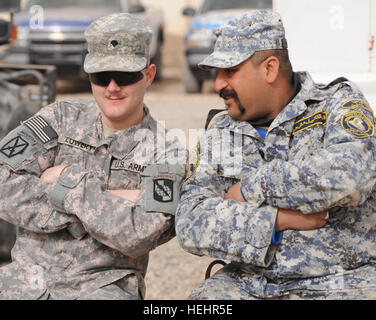 La CPS de l'armée américaine. Joshua Lowery (à gauche) de Senoia, Ga., 982e de l'entreprise de Caméra de combat (Airborne), pose avec un policier national iraquien de 8e Brigade, 2e Division, au poste de sécurité commune, Beladiyat Muhallah Beladiyat dans 732, l'Est, Bagdad, Irak, le 21 février 2009. La CPS. Lowery est à Beladiyat JSS pour documenter des soldats américains de F Compagnie, 2e Bataillon du 505th Parachute Infantry Regiment, 3e Brigade Combat Team, 82e Division aéroportée, la conduite de la formation de mécanicien Humvee avec la police nationale irakienne. La formation à la sécurité commune Humvee Gare 153082 Beladiyat Banque D'Images