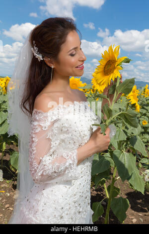 Belle jeune femme posant dans un champ de tournesol Banque D'Images