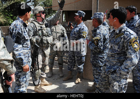 La 1ère Armée américaine, le Lieutenant Andrew Osborne de Birmingham, au Michigan, le chef de section du 3e peloton, Compagnie Bravo, 1er Bataillon du 505th Parachute Infantry Regiment, 3e Brigade Combat Team, 82e Division aéroportée, fait des plans avec des policiers irakiens à partir de la 3e compagnie, 3e Bataillon, 7e Brigade de la Police nationale, 2e Division de la Police nationale, pour visiter un quartier de Bagdad, l'Iraq, de se présenter à certains des résidents locaux dans le domaine le 16 mars 2009. 158521 patrouille à Bagdad Banque D'Images