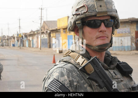 La 1ère Armée américaine, le Lieutenant Steve Smith de Raleigh, N.C., de 3e Brigade Combat Team, 82e Division aéroportée, assure la sécurité de l'ARMÉE AMÉRICAINE Le Colonel Timothy McGuire, commandant de la 3e Brigade Combat Team, 82e Division aéroportée, à l'extra-cordon de sécurité établi autour de la scène de combat entre les forces de sécurité irakiennes et renegade membres du Fils de l'Iraq, dans le quartier de l'est Al-Fadhel Bagdad, Irak, le 29 mars 2009. Conférence de presse à Al Fadhel 164026 Banque D'Images