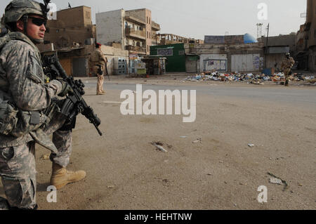 L'ARMÉE AMÉRICAINE Ryan Higgins de 3e Brigade Combat Team, 82e Division aéroportée, assure la sécurité de l'ARMÉE AMÉRICAINE Le Colonel Timothy McGuire, commandant de la 3e Brigade Combat Team, 82e Division aéroportée au cours d'une visite à l'Al-Fadhel quartier, dans l'est de Bagdad, l'Iraq, le 29 mars 2009. Le colonel McGuire est de visiter le théâtre de combats entre les forces de sécurité irakiennes et renegade membres du Fils de l'Irak. Conférence de presse à Al Fadhel 164038 Banque D'Images