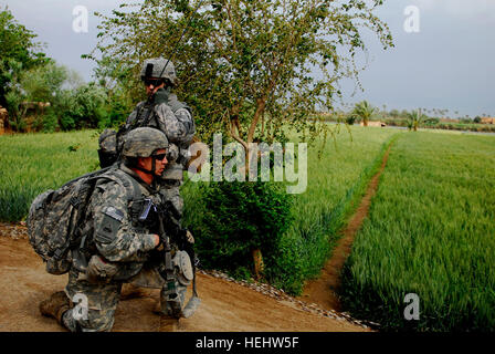 La CPS. Robert Cooper (à genoux), de Glouster, Ohio, et le Maj Travis Thompson, de Bakersfield, Californie, membres du 1er Bataillon, 6e Régiment d'infanterie, 2e Iron Brigade Combat Team, 1re Division blindée, Multi-National Division-Baghdad lors de l'opération al-Sakar, 12 avril. Les deux soldats de la Iron Brigade a aidé le Bataillon Commando, 17e brigade de l'armée iraquienne, en recherchant l'Owesat salon pour les insurgés, les caches d'armes et d'explosifs. Les deux forces but est d'organiser et de sécuriser la zone Owesat insurgés et refuser la possibilité d'utiliser la zone à lancer des attaques dans les rues de Bagdad. Fer à Repasser Briga Banque D'Images