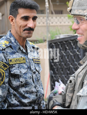 Le Brigadier-général de la police nationale irakienne Ali Ibraheem Dabown (à gauche), commandant de la 8e brigade, 2e Division, la police nationale irakienne, l'armée américaine et le lieutenant-colonel Louis Zeisman de Fayetteville, N.C., commandant du 2e Bataillon du 505th Parachute Infantry Regiment, 3e Brigade Combat Team, 82e Division aéroportée, sourire alors que la distribution de bonbons dans un voisinage local dans Beladiyat, l'est de Bagdad, l'Iraq, le 12 avril 2009. La distribution de bonbons et de jouets dans Beladiyat 166351 Banque D'Images