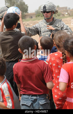 Le Lieutenant-colonel de l'ARMÉE AMÉRICAINE Michael Shinners, commandant adjoint de la 3e Brigade Combat Team, 82e Division aéroportée, donne un ballon de soccer donnés à des enfants iraquiens dans les Al-Madain Région de l'est de Bagdad, l'Iraq, le 18 avril 2009. Des soldats américains sont en train d'évaluer les terrains de soccer dans la région, et la distribution de ballons de soccer a fait don à la mémoire d'un soldat américain tombé, la FPC. Nick Madaras. L'évaluation des terrains de soccer à Bagdad 167605 Banque D'Images