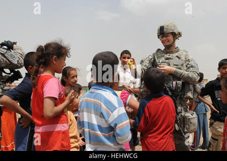 La CPS de l'armée américaine. Nicole Willson de Hillsdale, Mich., infirmier du Quartier général et l'entreprise de l'Administration centrale, 3e Brigade Combat Team, 82e Division aéroportée, distribue des dons de jouets aux enfants iraquiens locaux dans l'Al-Madain Région de l'est de Bagdad, l'Iraq, le 18 avril 2009. Des soldats américains sont dans le domaine de l'évaluation des terrains de soccer et la distribution de ballons de soccer a fait don à la mémoire d'un soldat américain tombé, la FPC. Nick Madaras. L'évaluation des terrains de soccer à Bagdad 167644 Banque D'Images