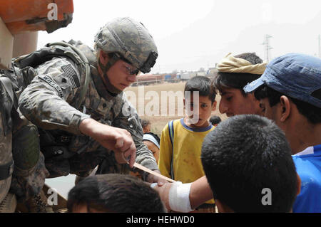 La CPS de l'armée américaine. Nicole Willson de Hillsdale, Mich., infirmier du Quartier général et l'entreprise de l'Administration centrale, 3e Brigade Combat Team, 82e Division aéroportée, les bandages le bras blessé d'Irakiens locaux, dans l'al-Madain Région de l'est de Bagdad, l'Iraq, le 18 avril 2009. Des soldats américains sont dans le domaine de l'évaluation des terrains de soccer et la distribution de ballons de soccer a fait don à la mémoire d'un soldat américain tombé, la FPC. Nick Madaras. L'oeil sur al-Madain 166508 Banque D'Images