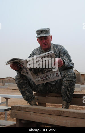 Le Sgt commande. Le major Robert Sweeney, le sergent-major de commandement de la 81e Brigade Combat Team, Washington Army National Guard, consulte les résultats sportifs dans 'Stars and Stripes' durant le camp Ramadi Softball League championnat match sur Camp Ramadi, en Irak, le 25 avril. 81e Brigade Combat Team 169551 Banque D'Images