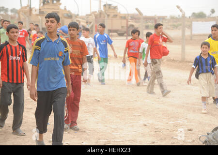 Les garçons irakiens arrivent à participer à un match de soccer pour les jeunes de l'Est, Karadah Bagdad, Iraq, le 8 mai. L'iraquien local public était invité à regarder le match suivi d'un match entre des équipes conjointes de soldats américains de la 3e Brigade Combat Team, 82e Division aéroportée, et la police nationale irakienne dans un terrain de soccer. Match de football à Bagdad, Iraq 172298 Banque D'Images