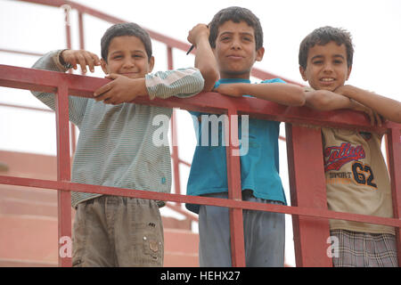 Les garçons irakiens locaux s'appuyer sur une balustrade de l'est donnant sur un terrain de soccer à l'Est, Karadah Bagdad, l'Iraq, le 8 mai. L'iraquien local public était invité à regarder un match de football de la jeunesse suivie d'un match entre des équipes conjointes de soldats américains de la 3e Brigade Combat Team, 82e Division aéroportée et de la police nationale irakienne. Match de football à Bagdad, Iraq 172302 Banque D'Images