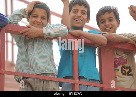 Les garçons irakiens locaux s'appuyer sur une balustrade de l'est donnant sur un terrain de soccer à l'Est, Karadah Bagdad, l'Iraq, le 8 mai. L'iraquien local public était invité à regarder un match de football de la jeunesse suivie d'un match entre des équipes conjointes de soldats américains de la 3e Brigade Combat Team, 82e Division aéroportée et de la police nationale irakienne. Match de football à Bagdad, Iraq 172310 Banque D'Images