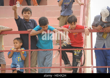 Les garçons irakiens locaux s'appuyer sur une balustrade de l'est donnant sur un terrain de soccer à l'Est, Karadah Bagdad, l'Iraq, le 8 mai. L'iraquien local public était invité à regarder un match de football de la jeunesse suivie d'un match entre des équipes conjointes de soldats américains de la 3e Brigade Combat Team, 82e Division aéroportée et de la police nationale irakienne. Match de football à Bagdad, Iraq 172311 Banque D'Images