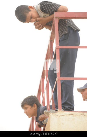 Les garçons irakiens locaux s'appuyer sur une balustrade de l'est donnant sur un terrain de soccer à l'Est, Karadah Bagdad, l'Iraq, le 8 mai. L'iraquien local public était invité à regarder un match de football de la jeunesse suivie d'un match entre des équipes conjointes de soldats américains de la 3e Brigade Combat Team, 82e Division aéroportée et de la police nationale irakienne. Match de football à Bagdad, Iraq 172313 Banque D'Images