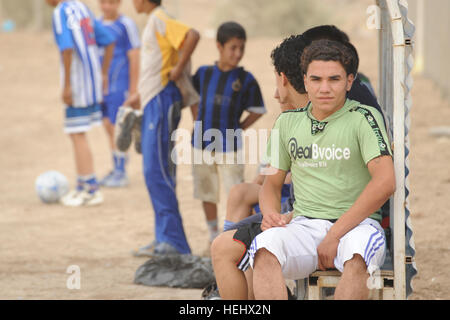 Les garçons irakiens d'attente à l'écart lors d'un match de soccer pour les jeunes de l'Est, Karadah Bagdad, Iraq, le 8 mai. L'iraquien local public était invité à regarder le match suivi d'un match entre des équipes conjointes de soldats américains de la 3e Brigade Combat Team, 82e Division aéroportée, et la police nationale irakienne dans un terrain de soccer. Match de football à Bagdad, Iraq 172314 Banque D'Images