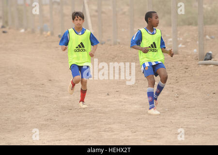 Les garçons irakiens réchauffement avant d'un match de soccer pour les jeunes dans l'est de Bagdad, Karadah, l'Iraq, le 8 mai. L'iraquien local public était invité à regarder le match suivi d'un match entre des équipes conjointes de soldats américains de la 3e Brigade Combat Team, 82e Division aéroportée, et la police nationale irakienne dans un terrain de soccer. Match de football à Bagdad, Iraq 172317 Banque D'Images