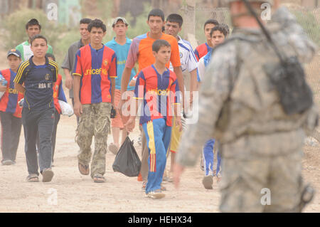 Les garçons irakiens arrivent à participer à un match de soccer pour les jeunes de l'Est, Karadah Bagdad, Iraq, le 8 mai. L'iraquien local public était invité à regarder le match suivi d'un match entre des équipes conjointes de soldats américains de la 3e Brigade Combat Team, 82e Division aéroportée, et la police nationale irakienne dans un terrain de soccer. Match de football à Bagdad, Iraq 172323 Banque D'Images