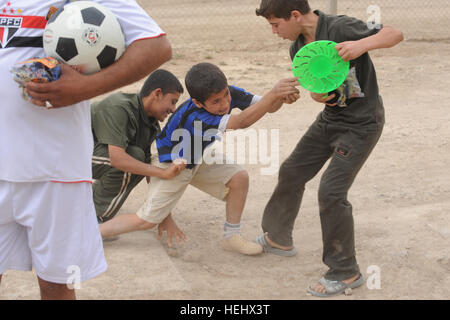 Les garçons irakiens lutte pour les jouets distribués au cours d'un jeu de football Karadah, Bagdad, l'Iraq de l'est le 8 mai. L'iraquien local public était invité à regarder des équipes conjointes de soldats américains de la 3e Brigade Combat Team, 82e Division aéroportée et de la police nationale irakienne de jouer les uns contre les autres dans un terrain de soccer. Match de football à Bagdad, Iraq 172408 Banque D'Images