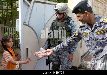 Brig iraquien. Le général Ali Ibraheem Dabown, commandant de la 8e Brigade de la Police nationale, 2e Division NP, donne une jeune fille iraquienne un animal en peluche à l'opération Asfah Ramlyah, une opération de déminage, le 28 mai dans la ville de Sumer Al-Ghadier, situé dans le district d'Nissan 9 Bagdad. NPs, parachutistes avec affecté à la 2e Bataillon du 505th Parachute Infantry Regiment, 3e Brigade Combat Team, 82e Division aéroportée, Multi-National Division-Baghdad, a effectué l'opération pour perturber les activités des insurgés et vérifier la zone pour des dispositifs explosifs de circonstance. (Photo par le Sgt. 1ère Cl Banque D'Images