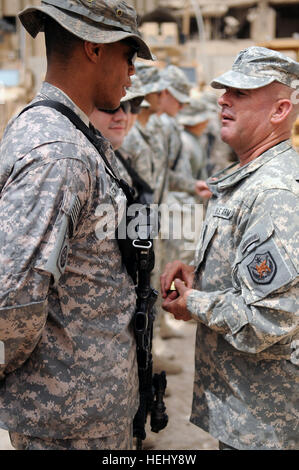 Le Commandement de l'armée américaine le Sgt. Le major Lawrence Wilson de Austin, Texas, sergent-major de commandement de la Force multinationale - Iraq, présente des pièces d'excellence pour les soldats américains de troupes spéciales brigade bataillon, 3e Brigade Combat Team, 82e Division aéroportée, en reconnaissance pour leur service au poste de sécurité commune, la loyauté, l'est de Bagdad, l'Iraq, le 8 juin. Le Sgt commande. Le Major Wilson Coins soldats à Bagdad, l'Iraq 178999 Banque D'Images