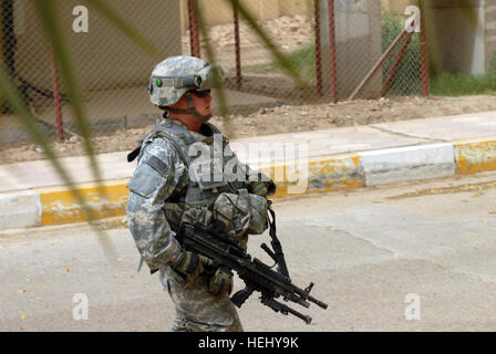 La CPS. Jon Stricklin, une escouade arme automatique gunner et sécurité personnelle de Greenville, N.C., attribuée à la société un "Enclumes, 252ème bataillon interarmes', 30e Brigade Combat Team lourds, les escortes son commandant de compagnie à une réunion à l'Est du District d'al-Rashid, ici, le 9 juin. Stricklin et ses collègues de la Garde nationale de Caroline du Nord à partir de la 30e ont été HBCT à Bagdad pendant environ cinq semaines. Sécurité personnelle pour un jour 178546 Banque D'Images