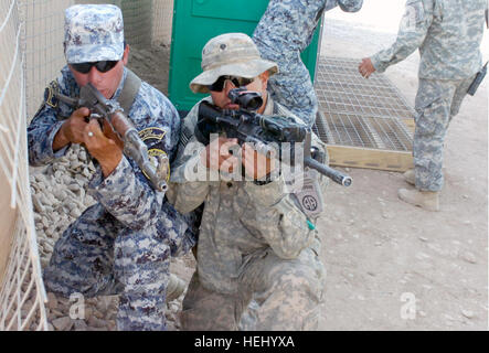 La CPS. Miguel Angel Trevino, d'Uvalde, Texas, attribué aux pays fournisseurs K, 5e, 73e Escadron de cavalerie, 82e Division aéroportée, Multi-National Division-Baghdad, montre un agent de la Police nationale affectés à la 3e Brigade NP, 1re Division NP la bonne façon de tenir son arme pendant un événement de formation le 24 juin à la base d'opérations avancée marteau, Iraq, situé à l'extérieur de l'est de Bagdad. L'événement de formation fait partie de l'escadron "Panther nouvellement développé Recon Training Academy." Les deux semaines de former et d'encadrer l'académie de l'escadron des Forces de sécurité irakiennes partenaires sur les habiletés de base du soldat comme leader des troupes Banque D'Images