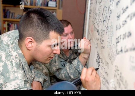 Le Sgt les soldats blessés. Brandon Deaton et le Sgt. Christopher A. Burrell signer le mur "Warriors", un endroit où les soldats en passant par l'hôpital peuvent signer leur nom et laisser des commentaires, au cours d'une visite de l'Armée de l'air sur l'hôpital théâtre Joint Base Balad, Iraq, 25 juin. Mur "guerrier". Deaton et Burrell, tous deux blessés au combat en Irak, faisaient partie d'un groupe de sept soldats ont donné l'occasion de revenir et de voir les changements qui s'était passé depuis leur première à gauche. (U.S. Photo de l'armée par la CPS. Brian A. Barbour) (U.S. Photo de l'armée par la CPS. Brian A. Barbour) Flickr - l'armée américaine - 'Warriors Banque D'Images