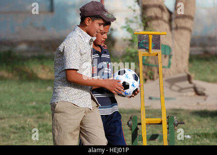 Deux garçons de l'orphelinat de Kut inspecter le nouveau ballon de soccer qu'ils ont reçu d'un 2e Bataillon, 20e Régiment d'artillerie de soldat pendant leur congé de la kids à l'Rehanah Haydaryah al-Family Park, province de Wasit, l'Iraq, le 26 juin. Dites adieu aux soldats orphelins irakiens avec l'interlocuteur, cadeaux 184795 Banque D'Images