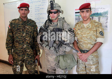 Circuit de l'armée américaine. Durl blanc, de Phoenix, Arizona), affecté au 1er Bataillon, 8e de cavalerie, 2e Brigade Combat Team, 1re Division de Combat, se tient entre deux soldats irakiens à la station de police irakienne dans Dubbis, l'Iraq, le 11 août. Station de police irakienne 196102 Banque D'Images