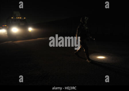 Un guide au sol descend de son véhicule et, avec l'aide de sa lampe de poche, escorte le véhicule pour le moment les Marines américains affectés à l'équipe de combat régimentaire - 6, Multi National Force - à l'Ouest, se charge et de quitter le Camp Ramadi, en Irak, le 17 septembre, pour leur dernière fois dans le cadre de l'opération Iraqi Freedom. L'équipe de combat régimentaire - 6 se prépare à redéployer 208399 Banque D'Images