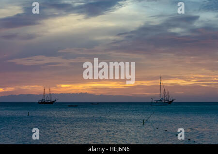 Coucher de soleil avec des bateaux ancrés sur la mer par la baie. L'image a été prise à Aruba, dans la mer des Caraïbes. Banque D'Images